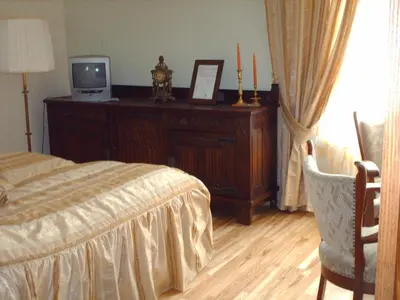 a bedroom with a bed and a tv on a dresser at Hotel Centras in Šakiai