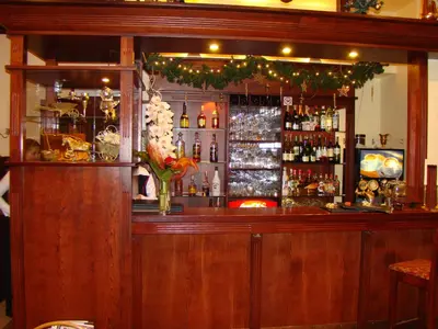 a wooden bar with a vase of flowers at Hotel Centras in Šakiai