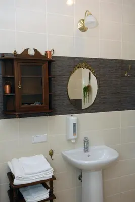 a bathroom with a sink and a mirror at Hotel Centras in Šakiai