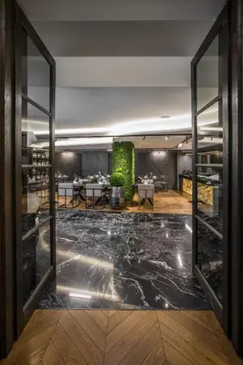 a view of a dining room with tables and windows at Hotel Pacai, Vilnius, a Member of Design Hotels in Vilnius