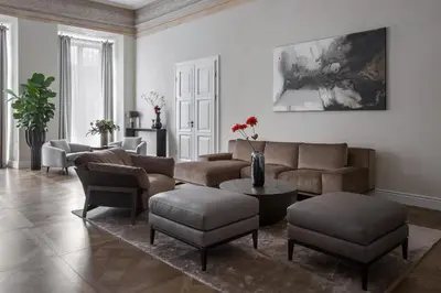a living room with a couch and a table and chairs at Hotel Pacai, Vilnius, a Member of Design Hotels in Vilnius