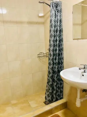 a bathroom with a sink and a shower curtain at Savan House 