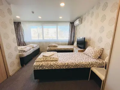 a small room with two beds and a tv at Savan House 