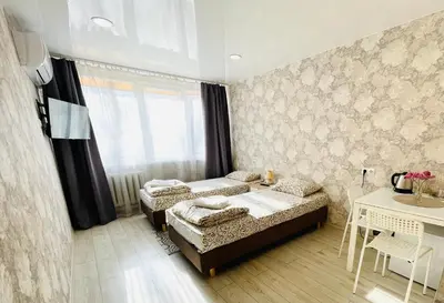 a bedroom with two beds and a table and a window at Savan House 