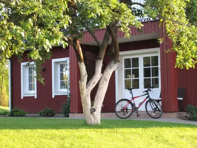a bike parked in front of a red house at Villa Sofia Boutique Trakai in Trakai