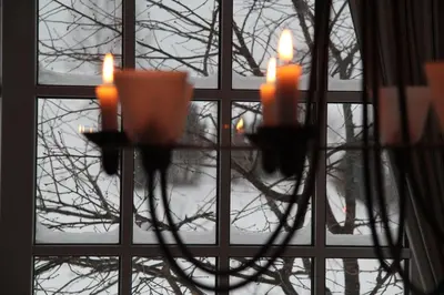 a chandelier with candles in front of a window at Villa Sofia Boutique Trakai in Trakai