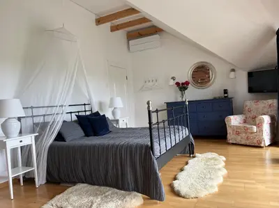 a bedroom with a bed and a couch and a chair at Villa Sofia Boutique Trakai in Trakai