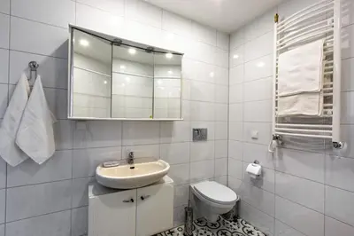 a white bathroom with a sink and a toilet at Apartamentai Laima in Druskininkai