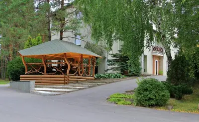 a wooden gazebo in front of a building at Apartamentai Laima in Druskininkai