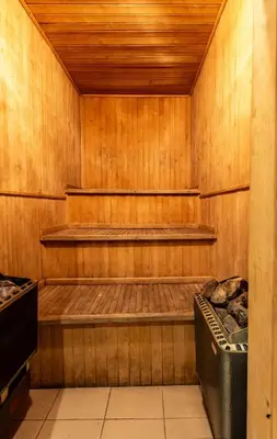a sauna with wooden walls and a trash can at Apartamentai Laima in Druskininkai
