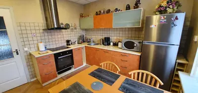 a kitchen with a table and a stainless steel refrigerator at ApartHotel SAVAS 2 Apartments in Kaunas and parking in Kaunas