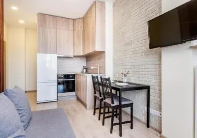 a kitchen with a table and chairs in a room at Apartamentai 