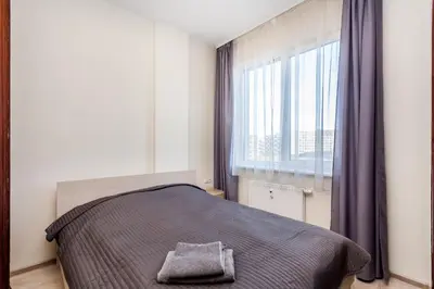 a bedroom with a bed and a large window at Apartamentai 