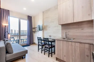 a kitchen with a sink and a table with chairs at Apartamentai 