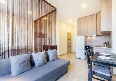 a living room with a couch and a table and a kitchen at Apartamentai 