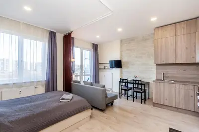 a bedroom with a bed and a couch and a table at Apartamentai 