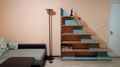 a staircase in the corner of a living room with a couch at Aleks in Zarasai