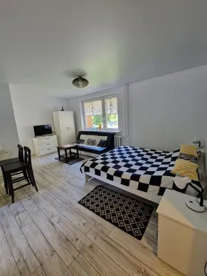 a bedroom with a bed with a checkered blanket at Lima Studio in Druskininkai