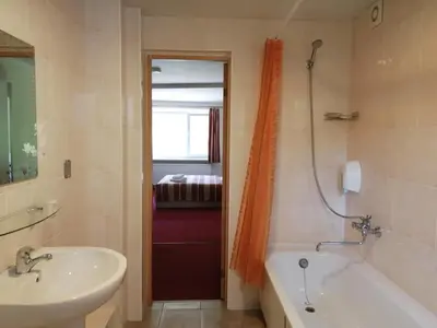 a bathroom with a tub and a sink and a bath tub at Idilė Bed & Breakfast - Visaginas in Visaginas