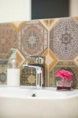 a bathroom sink with a faucet and a pink flower at Stay in Kaunas - Free Parking in Kaunas