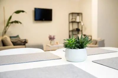a white vase with a plant sitting on a table at Stay in Kaunas - Free Parking in Kaunas