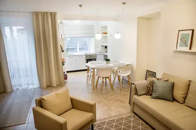 a living room and kitchen with a couch and a table at Stay in Kaunas - Free Parking in Kaunas
