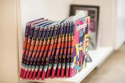 a shelf full ofcolored books on a shelf at Stay in Kaunas - Free Parking in Kaunas