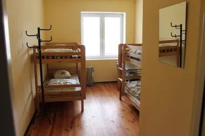 a room with three bunk beds and a window at Fortuna Hostel in Vilnius