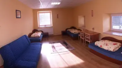 a living room with two blue couches and a table at Fortuna Hostel in Vilnius