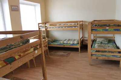 a room with three bunk beds and a window at Fortuna Hostel in Vilnius