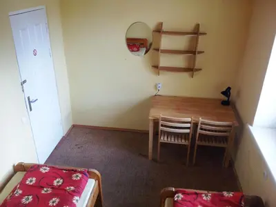 a small room with a table and chairs and a bed at Fortuna Hostel in Vilnius
