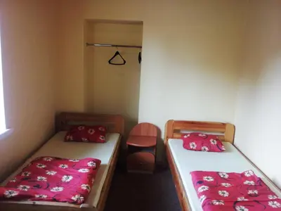 a room with two beds and a chair in it at Fortuna Hostel in Vilnius
