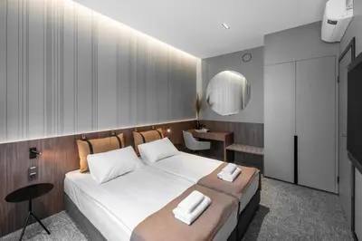 a bedroom with a large bed with white sheets at Pan Tadeusz in Vilnius