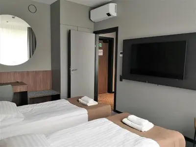 a hotel room with two beds and a flat screen tv at Pan Tadeusz in Vilnius