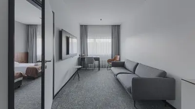 a hotel room with a couch and a bedroom at Pan Tadeusz in Vilnius