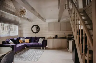 a living room with a purple couch and a kitchen at 5 stories in Inkartai