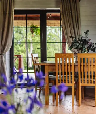 a dining room with a table and chairs and purple flowers at 5 stories in Inkartai