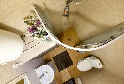 a bathroom with a toilet and a vase of flowers at 5 stories in Inkartai