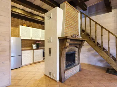 a kitchen with a brick fireplace and a staircase at 5 stories in Inkartai