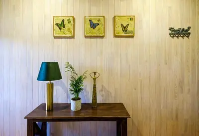 a table with a lamp and a plant on a wall at 5 stories in Inkartai