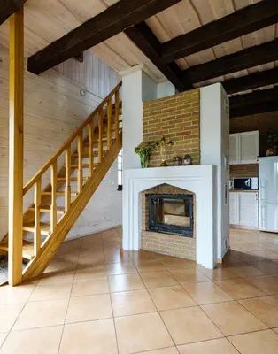 a living room with a fireplace and a staircase at 5 stories in Inkartai
