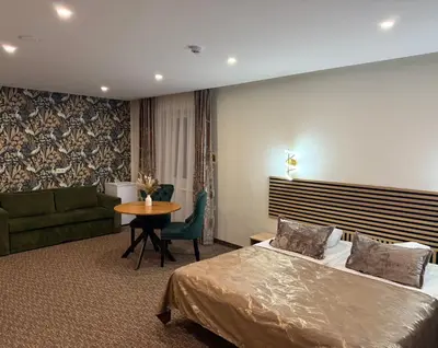 a hotel room with a bed and a couch and a table at Simona House in Šiauliai
