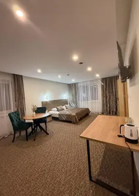a hotel room with a bed and a table at Simona House in Šiauliai