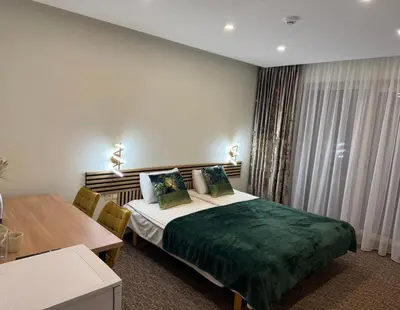 a hotel room with a bed and a table at Simona House in Šiauliai