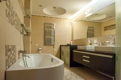 a bathroom with a large tub and two sinks at Natalex Europe in Vilnius