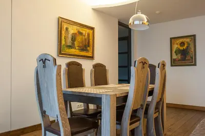 a dining room with a wooden table and chairs at Natalex Europe in Vilnius