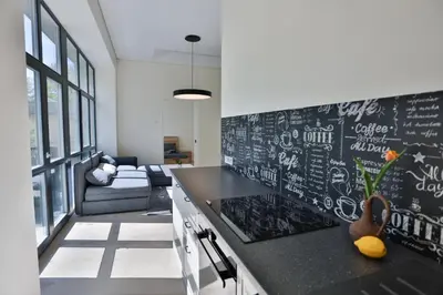 a kitchen with a black counter and a chalkboard wall at Loft on Owl Hill in Kaunas