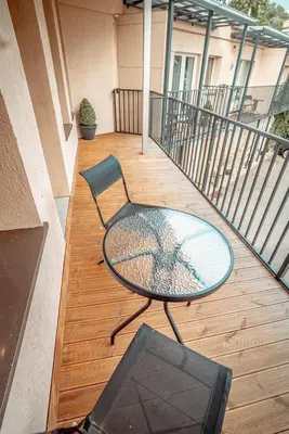 a patio with a table and a chair on a balcony at Alpetri Apartments in Kaunas