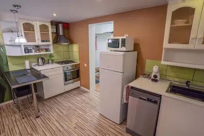 a kitchen with a white refrigerator and a microwave at Alpetri Apartments in Kaunas