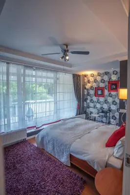 a bedroom with a large bed and a large window at Alpetri Apartments in Kaunas